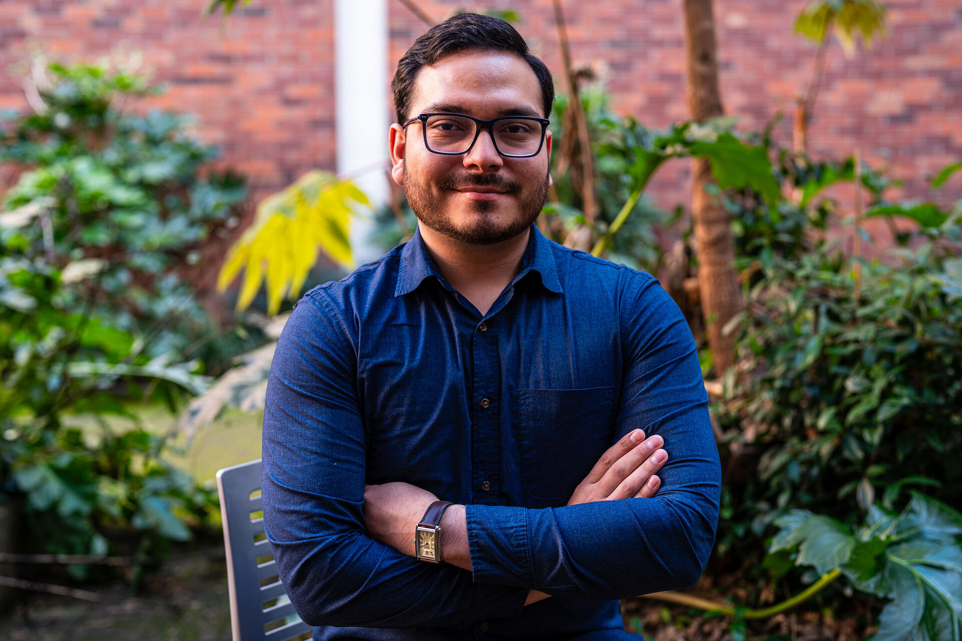 Andres sitting in a chair with his arms crossed