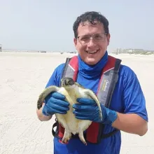Casner Pernice holding a small sea turtle